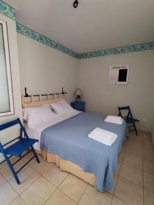 圣卡特琳娜迪纳德appartamento in pineta vista mare的一间卧室配有两张床和一张蓝色椅子