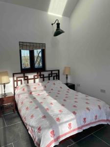 法尔茅斯Tresahor Studio的一间卧室配有一张带红色和白色棉被的床
