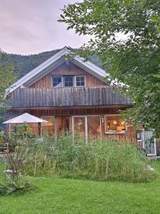 阿特湖畔翁特拉赫Countryhouse Lake Attersee - Sauna, Kamin, Seeblick的大型木制房屋设有窗户和草地