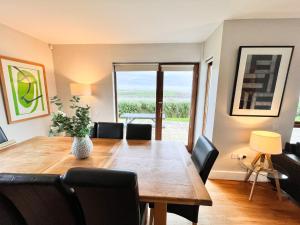 约尔Sea Haven · Tranquil Costal Retreat的一间带木桌和椅子的用餐室