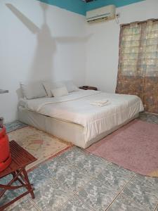 乌昆达Moha Airbnb Diani的一间卧室配有一张床和一把椅子