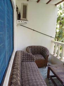 乌昆达Moha Airbnb Diani的窗户房间里一张沙发和一张桌子