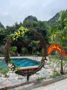 宁平Tam Coc Valley Homestay的游泳池四周环绕着鲜花,设有长凳