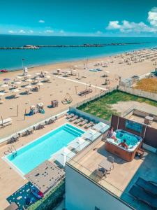 里米尼You & Me Beach Hotel的享有海滩和游泳池的空中景致
