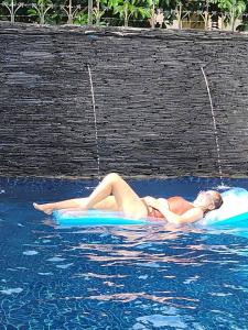 帕他仑山景旅馆的躺在水中的木筏上的比基尼妇女