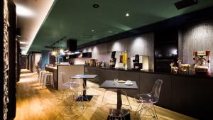 静冈Hotel Noir Blanc的餐厅设有酒吧,配有桌椅