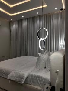 利雅德شقه فندقيه فاخرة的卧室配有一张带吊灯的大型白色床。