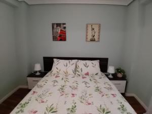 圣波拉Casa TARA的卧室配有一张床,墙上挂有两张照片