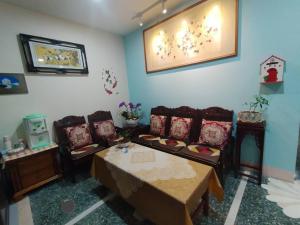 Xingang新港千顺民宿的客厅配有沙发和桌椅