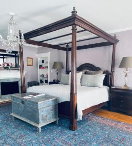 加纳诺克1000 Islands Bed and Breakfast-The Bulloch House的一间卧室配有一张天蓬床和一张茶几