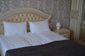 斯文托伊Floros simfonija Jūros的卧室内的一张带白色床单和枕头的床