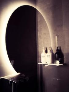贝特默阿尔卑Boutique Hotel La Cabane的浴室设有镜子和装有瓶子的架子