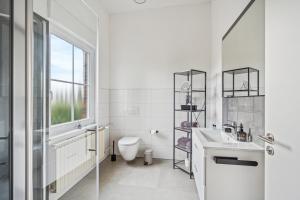 明登"Harmonie Hütte" warmherzig eingerichtetes und ruhig gelegenes Appartement!的白色的浴室设有卫生间和水槽。