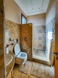 马拉喀什Exquisite Luxury Villa Golf的浴室配有卫生间、盥洗盆和淋浴。