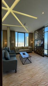 利雅德Rio Hotel Olaya的带沙发、电视和桌子的客厅
