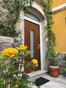 陶尔米纳Casanica-Taormina的前方有黄色花的建筑的门