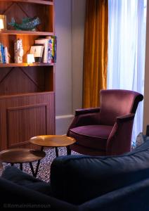 巴黎泰勒酒店的客厅配有椅子和2张桌子