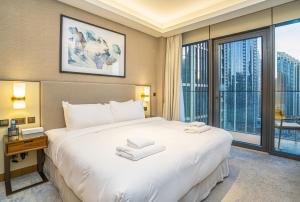 迪拜Vacay Lettings Luxury Living Address Opera Downtown的卧室设有一张白色大床和大窗户