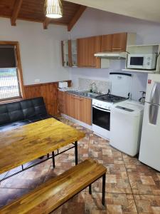 艾森港Aysen Bike Cabañas的厨房配有木桌和炉灶。