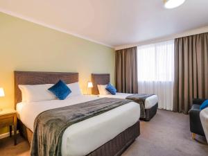 奥尔伯里阿尔伯里美居酒店的酒店客房设有两张床和窗户。