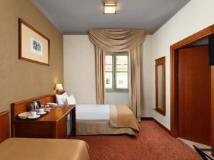 塞克希费黑瓦尔Mercure Szekesfehervar Magyar Kiraly的酒店客房设有床和窗户。