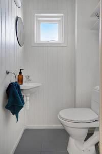 海宁格松Cozy 2-Bedroom Apartment - Free Parking的白色的浴室设有卫生间和窗户。