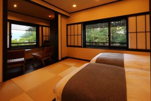 宫津市天桥立对桥楼酒店的一间卧室配有床、两个窗户和一张书桌