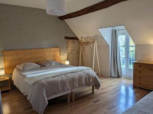 ThenayMaison dans belle longère - La Serrerie的一间卧室配有一张大床和木制床头板