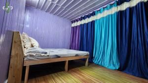 ShangarhSaatvik Space的色彩缤纷的窗帘间的一张床
