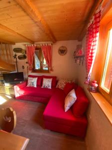佐尔尼耶戈迪Cosy Chalet on Pokljuka - Brunarica Tinkara的小屋内带红色沙发的客厅