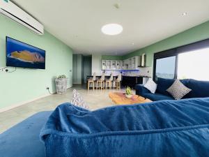 KigoAquarius Kigo Resort的客厅配有蓝色的沙发和桌子