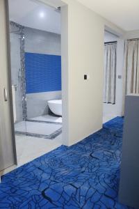KigoAquarius Kigo Resort的带淋浴的浴室以及蓝色和白色的地板。