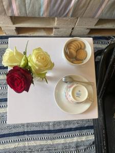 纳纽基Perfect Travel-Stop Room 3Km From Nanyuki Town - Charell View的盘子上放着玫瑰,咖啡和饼干