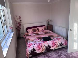 HornchurchCosy Spacious 2 bed flat Hornchurch high street的一间卧室配有一张粉红色玫瑰床