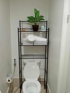 卡加盐德奥罗Loop Spacious Studio Unit的浴室设有卫生间,架子上种植了植物