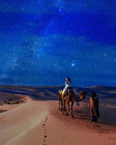 梅尔祖卡Merzouga Stars Luxury Camp的两个人在沙漠里骑马