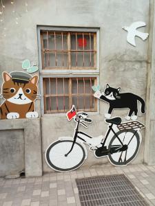 高雄fun高雄背包文旅的墙上挂着一幅猫和自行车的画