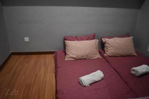 莎阿南i-City【CASA SERENE】~Wifi/Netflix/Parking~7pax的一张带两个枕头和紫色毯子的床
