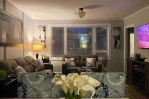 圣约翰斯Maple Blue的客厅配有沙发和鲜花桌