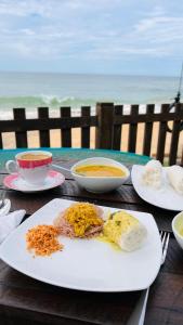 马特勒Hakuna Matara Beach Bungalows的餐桌,盘子,汤碗