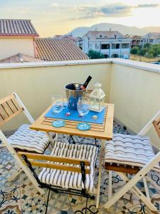 普拉Casa Vittorina的阳台上的桌椅和一瓶葡萄酒