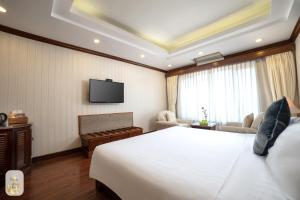 河内Thien Thai Hotel & Spa的酒店客房,配有床和电视