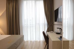 地拉那Metro Hotel Terminal的酒店客房配有一张床和一张书桌及一台电视