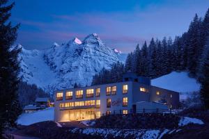 塔弗伊Hotel Ortles B&B的一座在晚上背景中拥有山脉的建筑