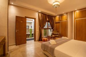 马拉喀什Riad Azia的卧室配有床、椅子和窗户。