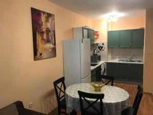 瓦尔纳Primorski Apartment的厨房配有桌子和白色冰箱。