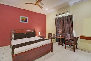 海得拉巴Hotel Ruma Near Nampally Railway Station的一间卧室设有一张床和红色的墙壁