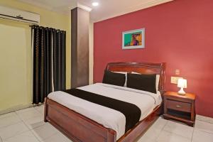 海得拉巴Hotel Ruma Near Nampally Railway Station的一间卧室配有一张红色墙壁的床
