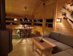 HoloKinnkosen - cabin with panoramic view for 6 persons的客厅配有沙发和桌子
