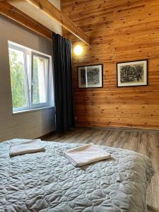 LisoveСадиба Бабина Лоза的一间带一张大床的卧室,位于带木墙的房间